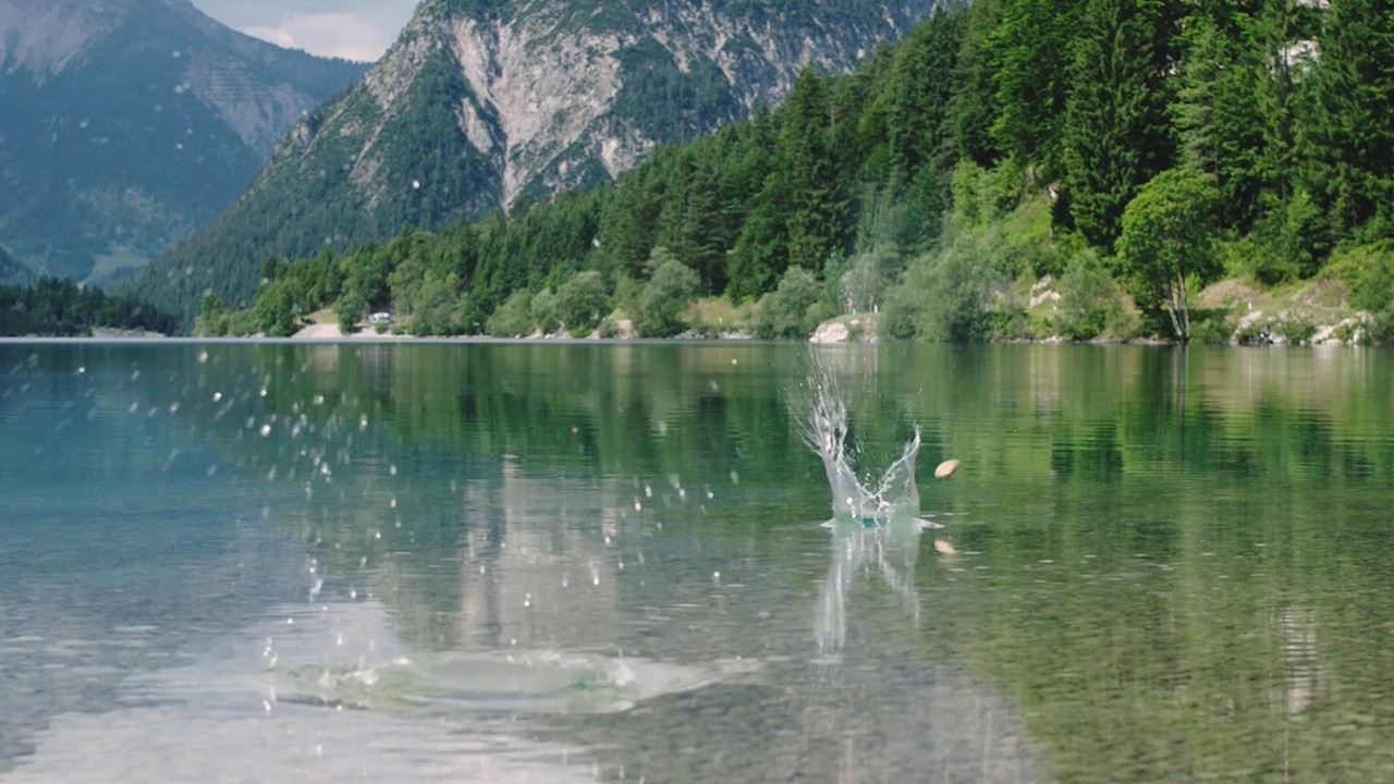 Pebble bouncing on clear lake water